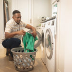 African American man pulling clothes out of a dryer