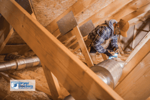man in an attic rerouting venting systems